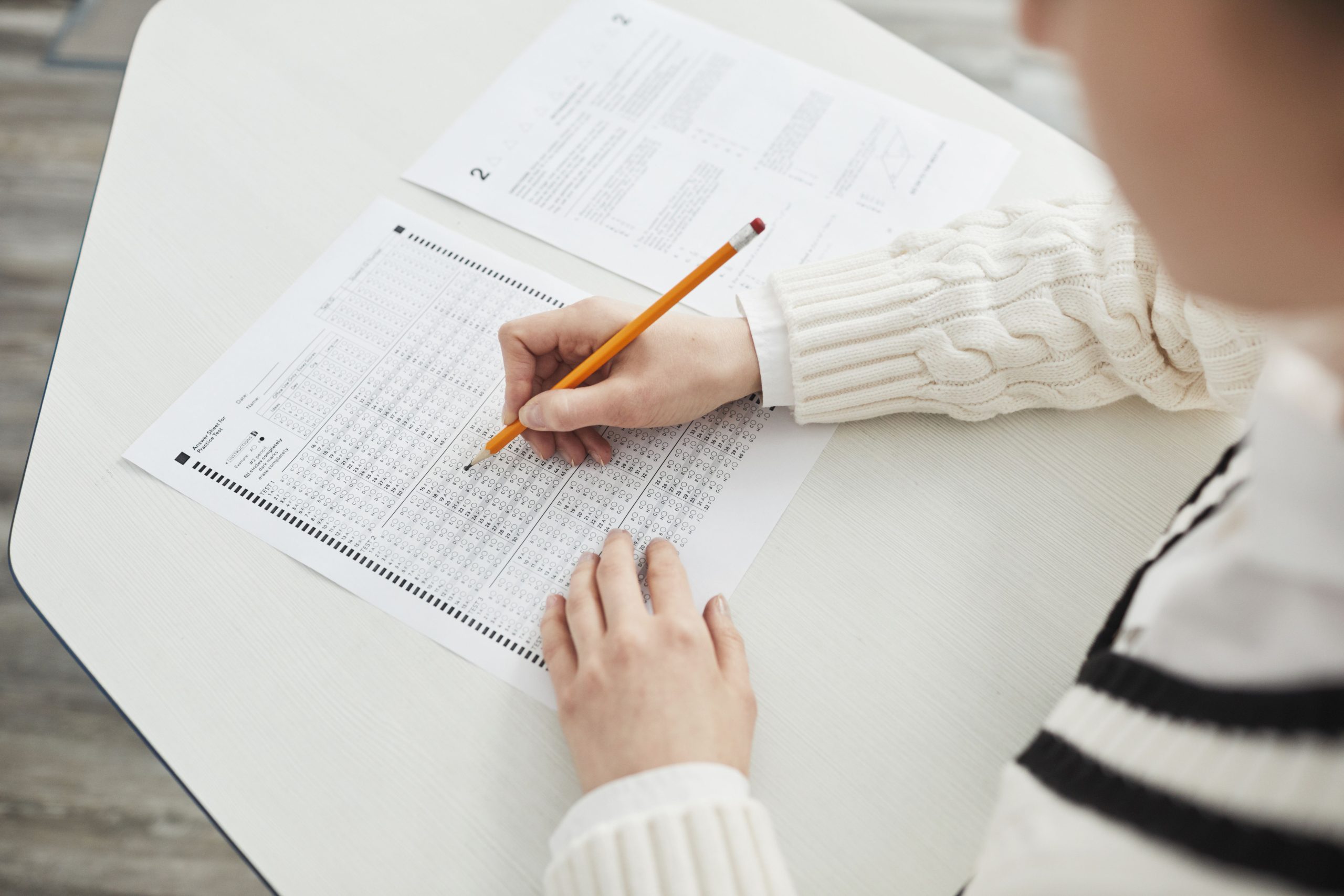 Student studying with notes and writing practice questions